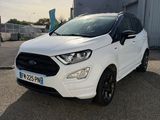 une Ford EcoPace blanche garée devant un immeuble