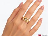 woman ' s hand holding a gold ring with a diamond on it
