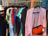 a lot of clothes hanging on a rack in a store