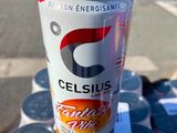 une canette de Celsius posée sur une table à côté de canettes de soda