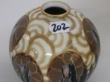 a brown and white vase sitting on a white surface