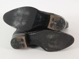pair of black leather shoes on a white surface with a white background