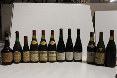 bottles of wine are lined up on a table in front of a white backdrop