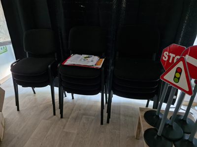 four black chairs in a room with a stop sign