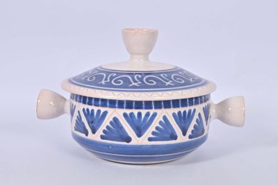 a blue and white bowl with a lid on a white table