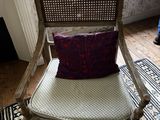 une chaise sur laquelle est posé un coussin, dans une pièce