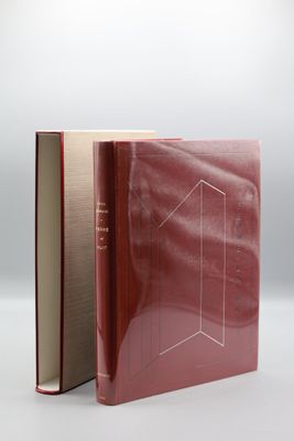 un livre ouvert à couverture rouge posé sur une table blanche