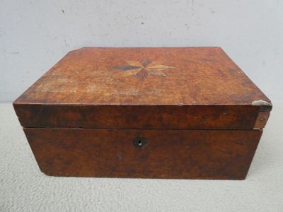 une vieille boîte en bois posée sur une surface blanche