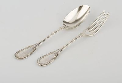 two forks and a spoon sitting next to each other on a table