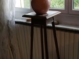 un vase de fleurs posé sur une table près d'une fenêtre