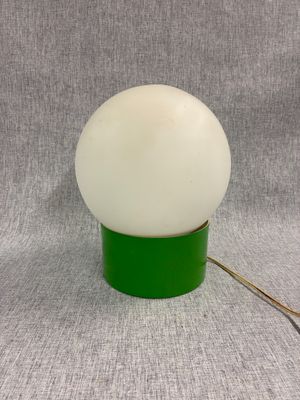 un gros plan d'une lampe verte surmontée d'une boule blanche