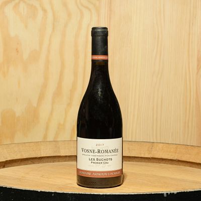a bottle of wine sitting on top of a barrel