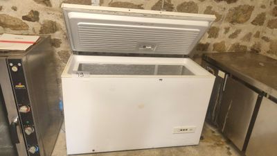 a white chest freezer sitting next to two other refrigerators