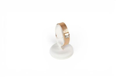 a close up of a ring on a stand on a white surface