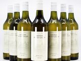 six bottles of wine are lined up in a row on a white surface