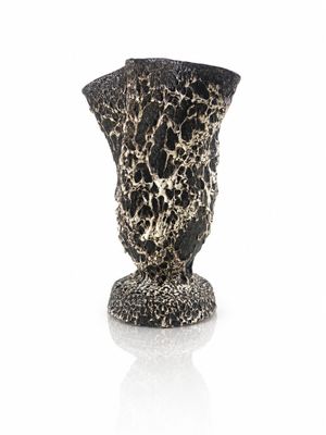a black and white vase sitting on a white surface