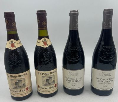 four bottles of wine are lined up in a row on a white surface