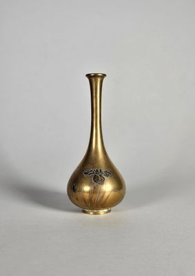 un vase ancien en laiton orné d'un motif floral sur le fond