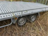 a flatbed trailer that is sitting in the grass