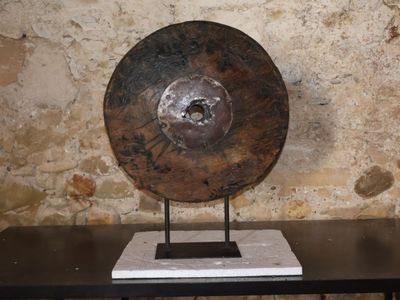 un grand objet métallique posé sur une table devant un mur de pierre