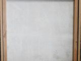 an empty picture frame sitting on top of a table next to a wall