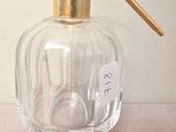 a clear glass bottle with a gold handle on a table