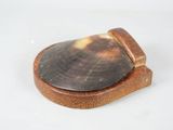 a wooden coaster with a shell on it on a white surface