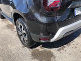 the rear end of a black car parked on the side of the road