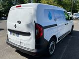 a white van parked in a parking lot with trees in the background
