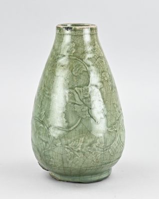vase émaillé vert orné d'un motif floral sur fond blanc
