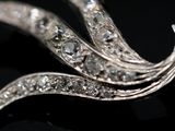 a close up of a diamond broochle on a black surface