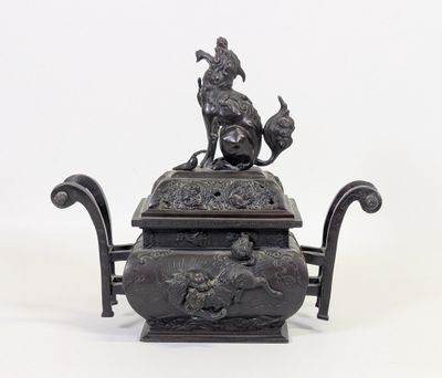 une statue représentant un homme et un chien posée sur une théière