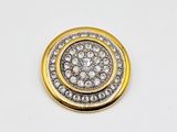 a close up of a gold and diamond button on a white background