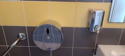 des toilettes et un lavabo dans une salle de bains carrelée de jaune et de gris