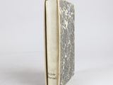 an old book sitting on top of a white table next to a white wall