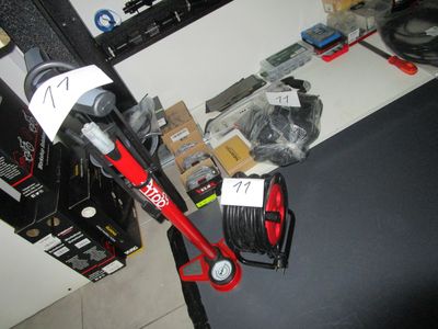 un aspirateur rouge et noir posé sur un bureau, à côté d'autres objets
