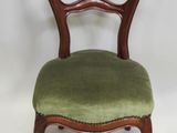 une image représentant une chaise dont l'assise est recouverte d'un tissu vert, sur fond blanc