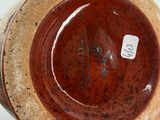 a brown vase sitting on a table with a tag on it