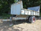 a rusted out dump truck sitting in a field