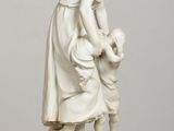statue of a woman with a child on a wooden table