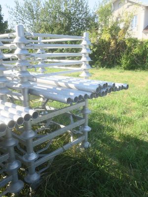 un banc blanc fait de tuyaux, posé dans l'herbe