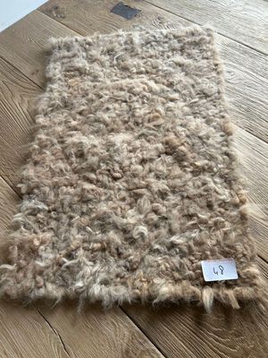 wool rug on a wooden table with a price tag on it