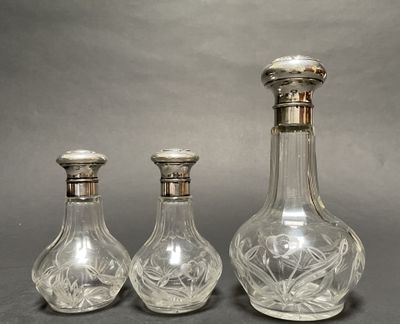 three glass decanters sitting next to each other on a table
