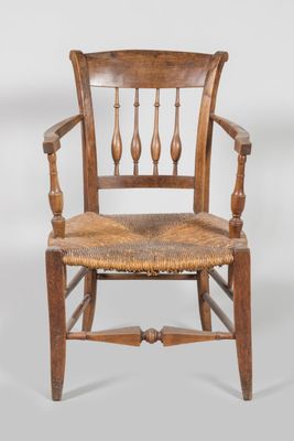 an old wooden chair with a woven seat and arm rest