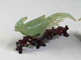 two figurines of birds sitting on a branch of a tree