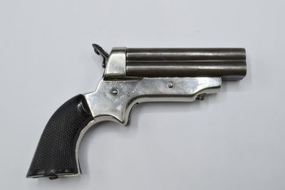 a close up of a revolver on a white surface