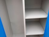 a close up of a blue cupboard with shelves in a room