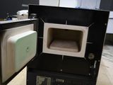 a person standing next to an open oven in a room