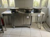 trois casseroles posées sur une table dans une cuisine avec une fenêtre