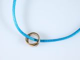 blue cord bracelet with a gold ring on a white background